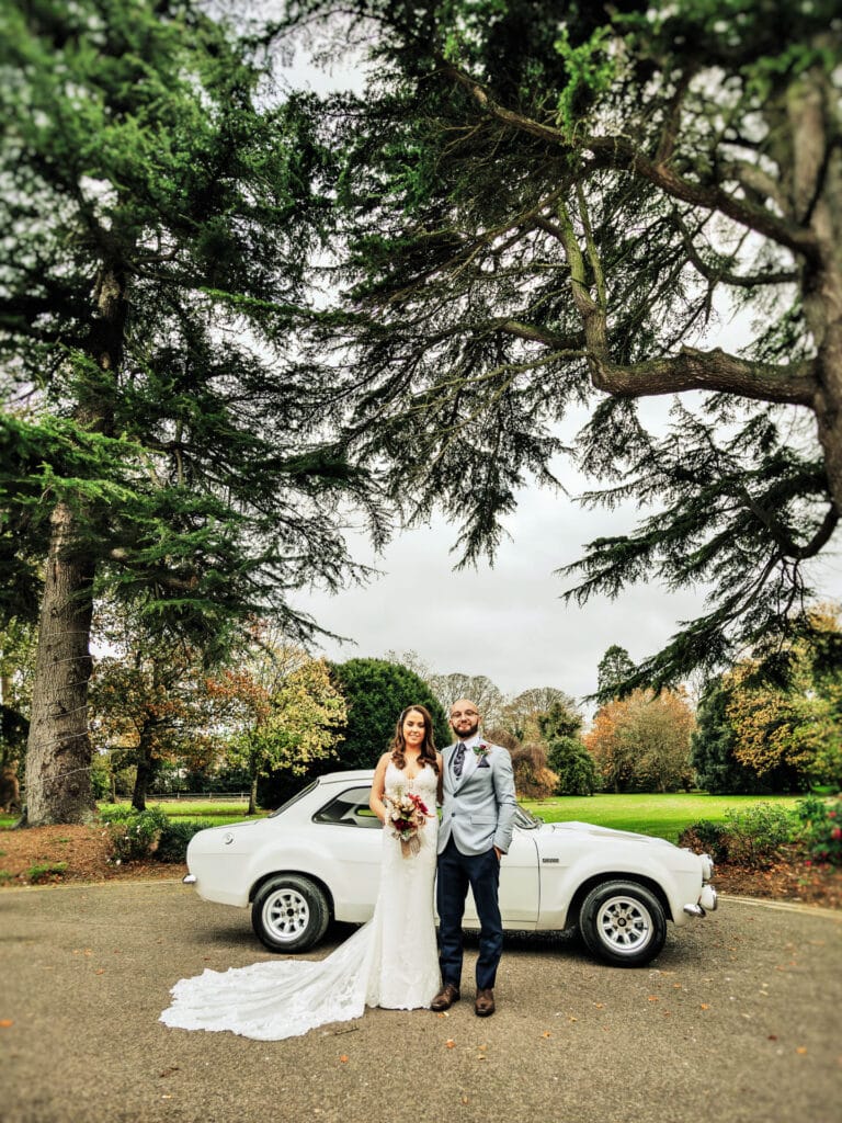 Wedding couple posing beneath trees at Roganstown