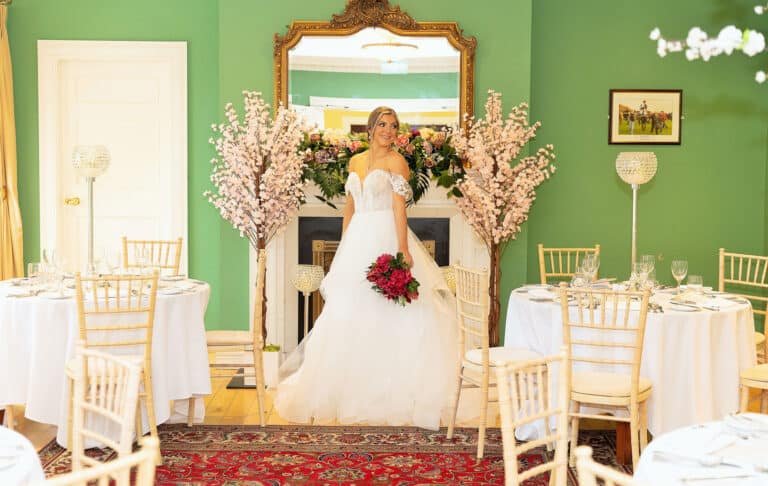 Bride in her wedding dress standing beside a window